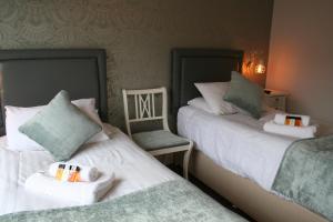 two beds sitting next to each other in a room at The Lady Elizabeth in Sudbury