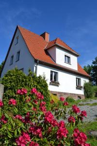 a white house with a red roof and pink flowers at Märchenherberge 7 Zwerge in Lichtenau