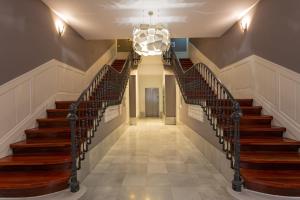 a hallway with stairs in a building with a chandelier at Casual Arriaga in Bilbao