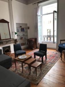 ein Wohnzimmer mit einem Sofa, Stühlen und einem Tisch in der Unterkunft Centre ville -cadre royal - appartement de charme. in Sète