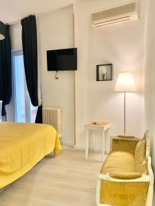 um quarto com uma cama amarela e um sofá em Terrazza Capruzzi em Bari