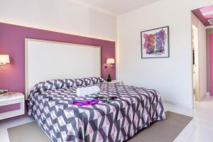a bedroom with a bed with a black and white comforter at The Purple Hotel - Adults Only in San Antonio