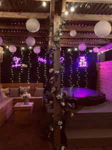 バリーキャッスルにあるThe Rose Garden Room - self contained studioの紫色の照明と照明が付いたバスタブが備わる客室です。