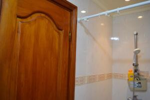 y baño con ducha y puerta de madera. en Appartement idéal Riad Al salam à 8 minutes de la plage du centre ville,Wifi et parking gratuits, en Agadir