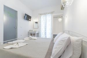 a white bedroom with a bed with white sheets at Katerina Babis Studios in Agios Prokopios