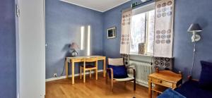 Cette chambre est dotée d'une table, de chaises et d'un mur bleu. dans l'établissement Kronlund Kursgård, à Vindeln