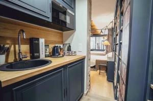 a kitchen with a sink and a room with a bedroom at Quartiers Enfants Rouges,Bretagne - Appartement d'architecte 4P in Paris