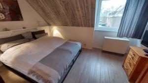 ein kleines Schlafzimmer mit einem Bett und einem Fenster in der Unterkunft Eichholzweg 18, App 34 in Heiligenhafen