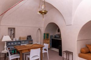 a dining room with an arched ceiling and a table and chairs at Dammusi IL SERRALH -Pantelleria- in Pantelleria