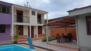 een huis met een zwembad en een tafel en stoelen bij Casa com piscina em condomínio in Paraty