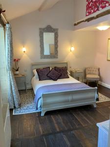 sypialnia z łóżkiem i lustrem na ścianie w obiekcie Le Patio Chambres et Tables d'Hôtes w mieście La Tour-Blanche