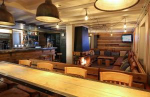 a bar with a large wooden table and chairs at CHALET AUBERGE - Les Mélèzes in Tignes