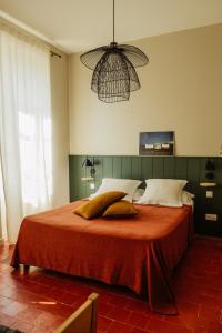 La Maison de Gruissan في جرويسان: غرفة نوم مع سرير كبير مع أوراق ومخدات برتقالية