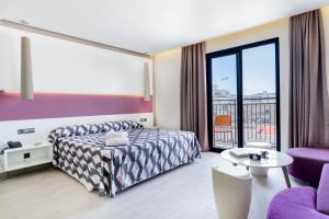 a hotel room with a bed and a balcony at The Purple Hotel - Adults Only in San Antonio