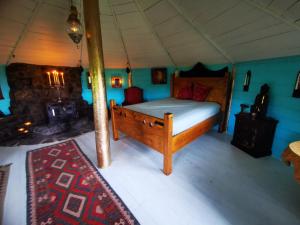 a bedroom with a wooden bed in a tent at The Round House in Newton Stewart