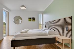 a bedroom with a large bed and a mirror at Lübker Golf Resort in Nimtofte