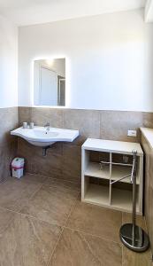 W łazience znajduje się umywalka i lustro. w obiekcie Rediesis Apartments w mieście Camerano