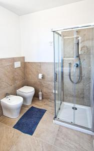 uma casa de banho com um chuveiro e um WC. em Rediesis Apartments em Camerano