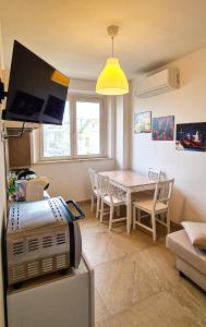 kuchnia i jadalnia ze stołem i telewizorem w obiekcie Rediesis Apartments w mieście Camerano
