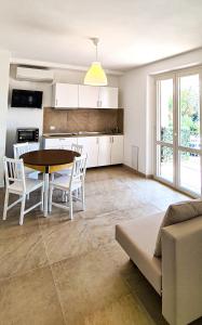 cocina y sala de estar con mesa y sillas en Rediesis Apartments, en Camerano