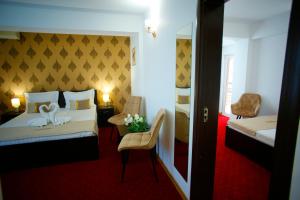 a hotel room with a bedroom with a bed and a chair at Casa Coral Mamaia Nord in Mamaia Nord