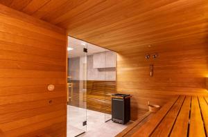 una sauna con paneles de madera y una pared de cristal en Iron Apartments, en Cracovia