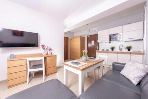ein Wohnzimmer mit Couch und Tisch und eine Küche in der Unterkunft Prywatny Apartament 413 w Arka Medical Spa przy plaży in Kołobrzeg