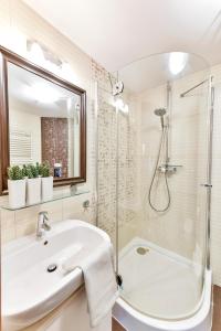 ein Badezimmer mit Waschbecken und Dusche in der Unterkunft Prywatny Apartament 413 w Arka Medical Spa przy plaży in Kołobrzeg + 19 Fotos