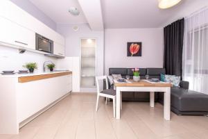 eine Küche und ein Wohnzimmer mit einem Tisch und einem Sofa in der Unterkunft Prywatny Apartament 413 w Arka Medical Spa przy plaży in Kołobrzeg