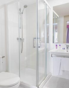 a bathroom with a shower with a toilet and a sink at The Purple Hotel - Adults Only in San Antonio