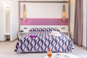 a bedroom with a purple and white bed with pink walls at The Purple Hotel - Adults Only in San Antonio