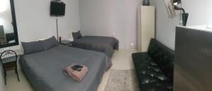 a hotel room with two beds and a television at Sheilas Self-Catering Overnight Accommodation in Polokwane