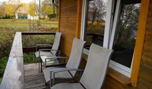 une véranda avec trois chaises, une table et une fenêtre dans l'établissement Apartamenty Lucky-ski, à Ustrzyki Dolne