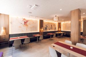 a restaurant with tables and chairs and paintings on the walls at The Purple Hotel - Adults Only in San Antonio