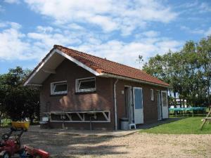 a small brick house with a roof at Trekkershuisje 't Zeeuws Knoopje in Aagtekerke