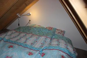 a bed with a blue comforter in a room at Trekkershuisje 't Zeeuws Knoopje in Aagtekerke