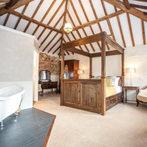 1 dormitorio con 1 cama y bañera en una habitación en Caistor Hall, en Norwich
