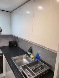 a kitchen counter with a sink in a kitchen at Fancy Basement Flat B in London