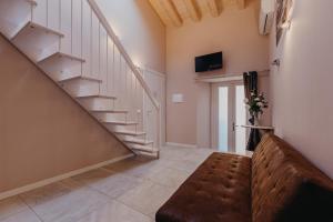 salon ze schodami i kanapą w obiekcie Le Due Dame w Manerba del Garda