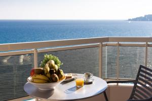 芒通的住宿－里瓦藝術溫泉酒店，阳台上的桌子上放着一碗水果