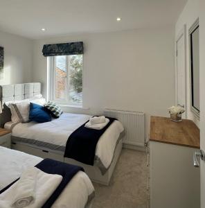 1 dormitorio con 2 camas y ventana en Hope House, en Swindon