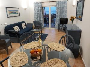 un soggiorno con tavolo, sedie e divano di Clube Alvor Ria - Luxury apartments with fabulous river views ad Alvor