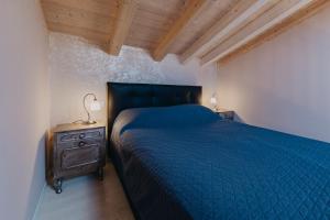 a bedroom with a blue bed and a wooden ceiling at Le Due Dame in Manerba del Garda