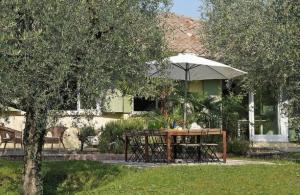 a table with an umbrella in front of a house at Villa Sweet Flower - with Private Pool and Garden in Manerba del Garda