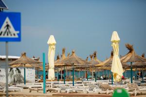 a group of umbrellas and chairs on a beach at Casa Coral Mamaia Nord in Mamaia Nord