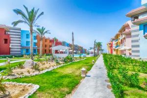 una calle en un complejo con palmeras y edificios en Porto matrouh chalets, en Marsa Matruh