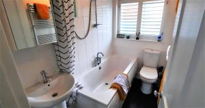 ein Badezimmer mit einer Badewanne, einem Waschbecken und einem WC in der Unterkunft Greenbrae East in Crieff