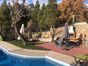 a swimming pool with chairs and umbrellas next to at Quinta da Fervença, private river place to relax.. in Sernancelhe