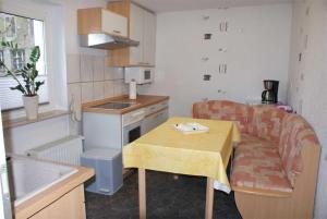 małą kuchnię z małym stołem, stołem i kanapą w obiekcie Ferienwohnung Patzig RUeG 2131 w mieście Patzig