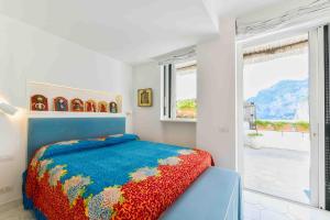 a bedroom with a bed and a large window at Le Rocce da Tragara, Tragara essential in Capri